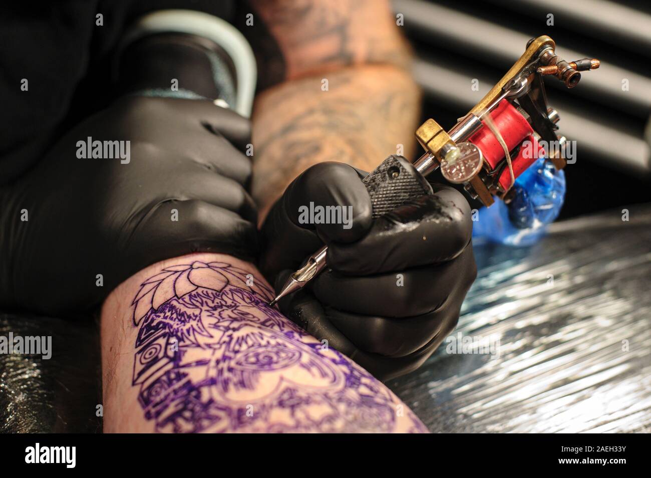 Tattoo Künstler Füllen in einem Herz Form Tattoo auf einem Arm. Stockfoto