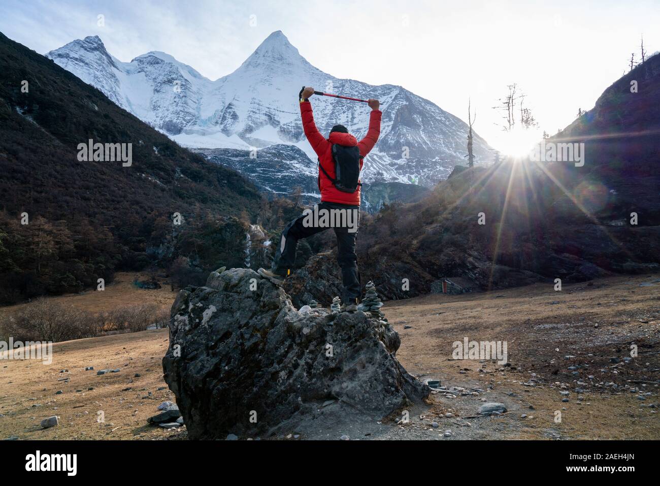 Erfolgreiche männliche Trekking auf dem Stein und Schnee Mountain Front Sicht von Yading Naturschutzgebiet China Stockfoto