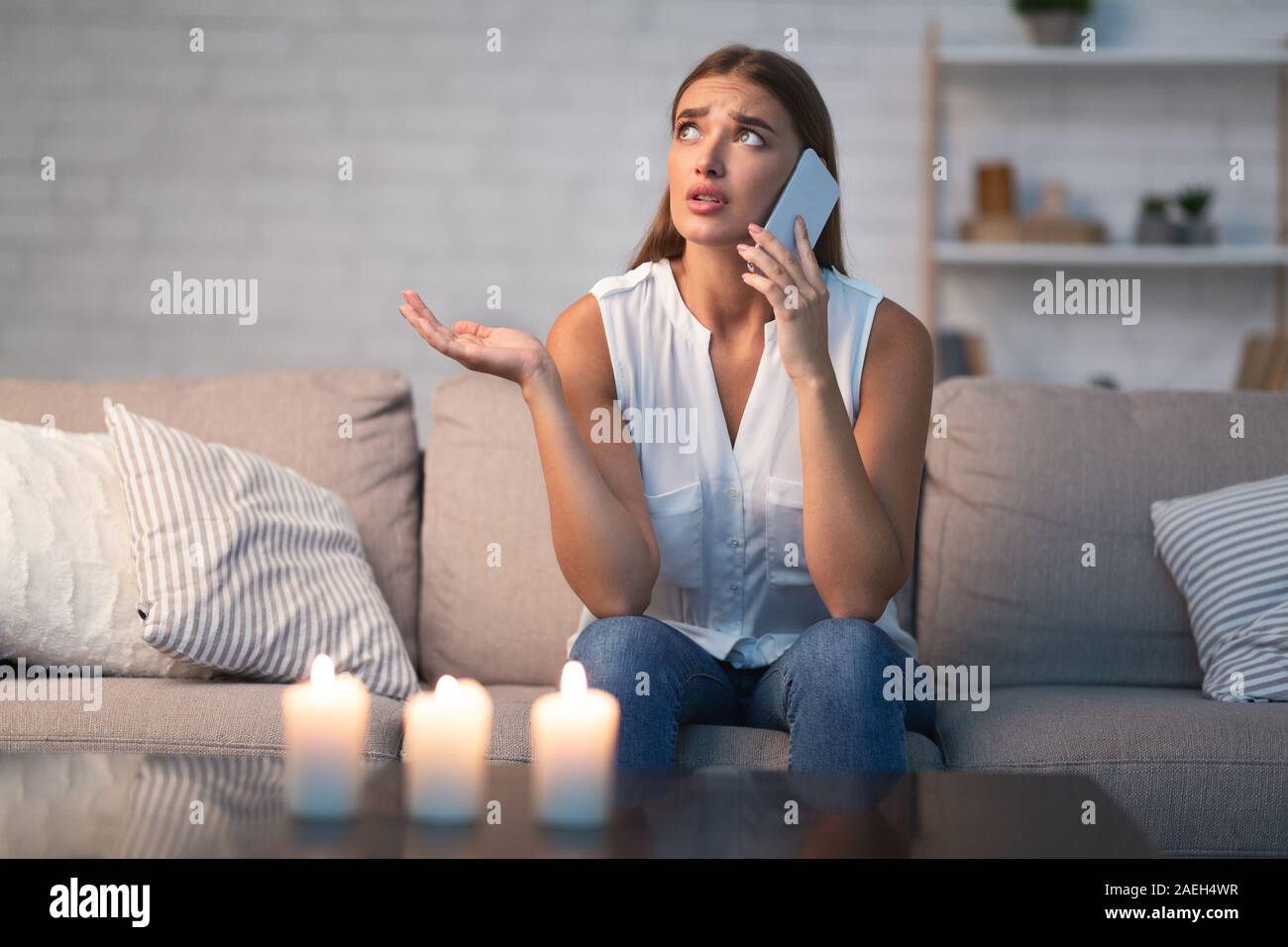 Mädchen Aufruf Freund auf ihn wartet zu Hause sitzen Stockfoto