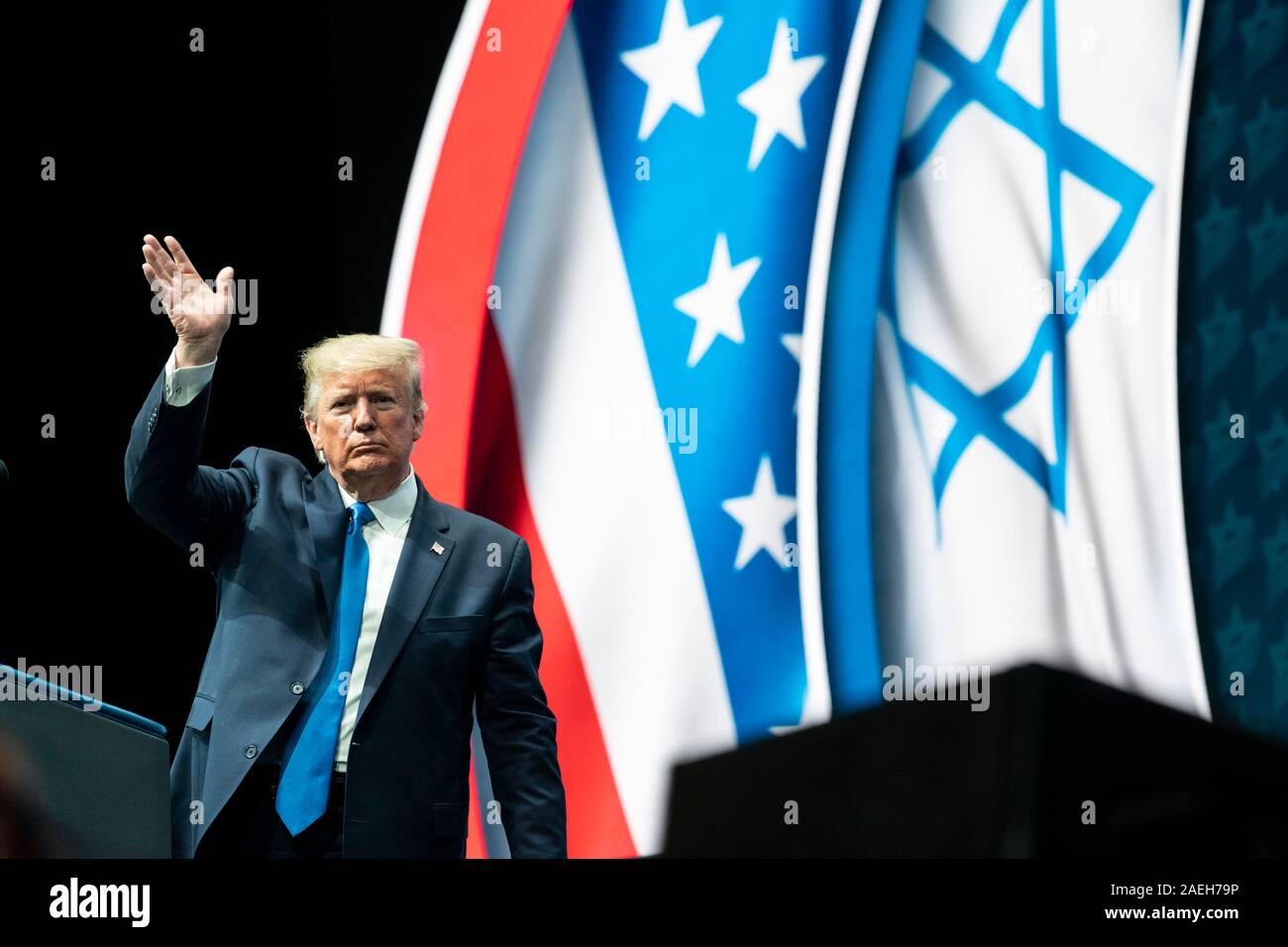 Us-Präsident Donald Trump Wellen, als er die Bühne der Israelischen Amerikanischer Rat nationalen Gipfel der Diplomat Beach Resort Dezember 7, 2019 in Hollywood, Florida zu adressieren. Stockfoto