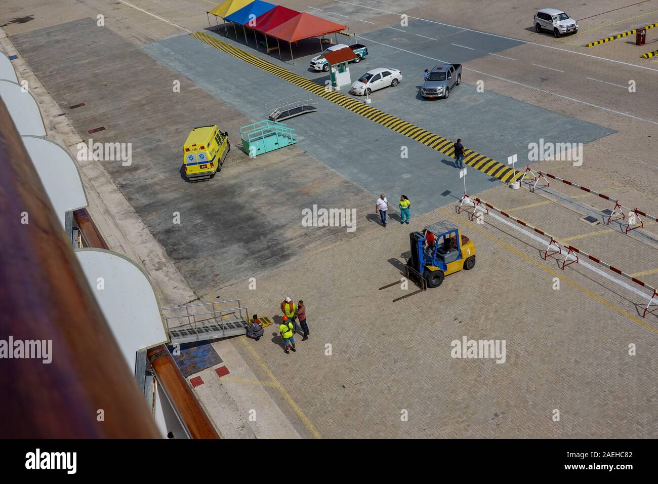 Aruba -11/4/19: Hafen Hafenarbeiter und cruise ship Crew arbeiten hart daran, die Einrichtung einer Rampe Passagiere aus dem Schiff zu transportieren. Stockfoto