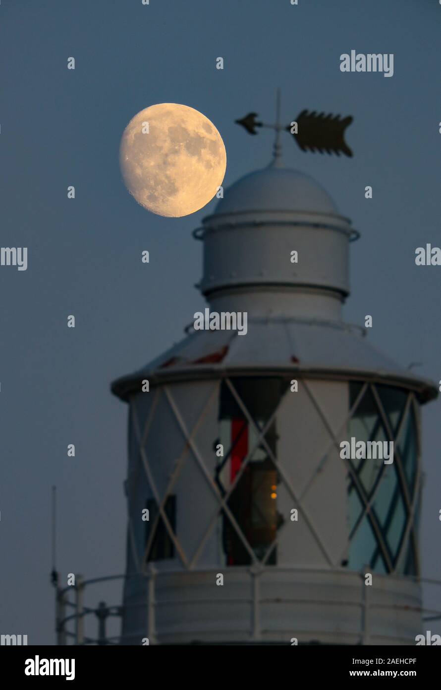 Keyhaven, Hampshire, UK. 9. Dezember 2019, UK Wetter: Das Waxing Gibbous Mond erhebt sich auf einem klaren Abend oben Hurst Point Lighthouse im Keyhaven, Hampshire vor der Full Cold Moon, die an diesem Donnerstag, 12. Dezember, 5.12 Uhr GMT. Kredit Stuart Martin/Alamy leben Nachrichten Stockfoto