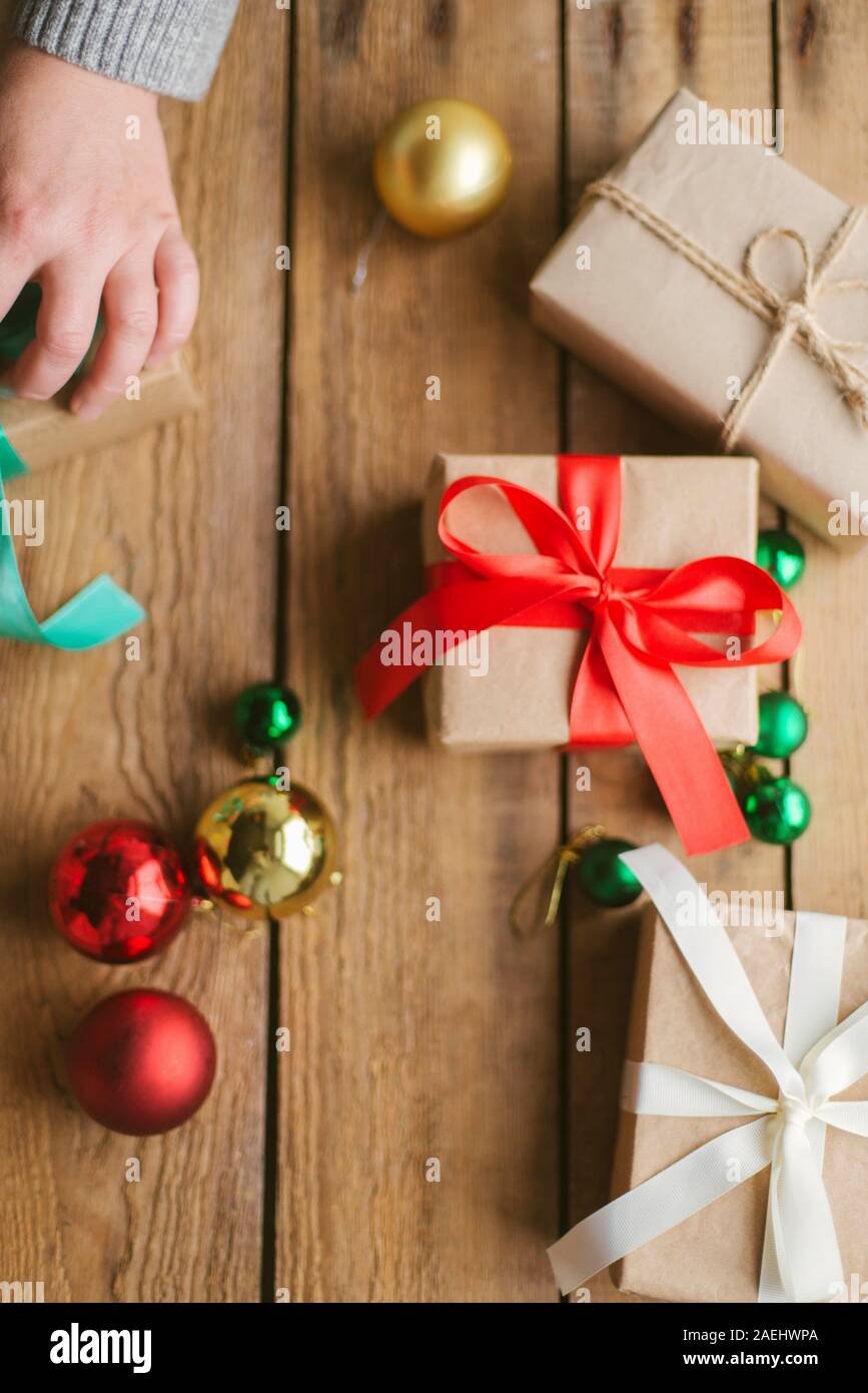Frau verpacken Weihnachten Geschenke auf Holz- Hintergrund Stockfoto
