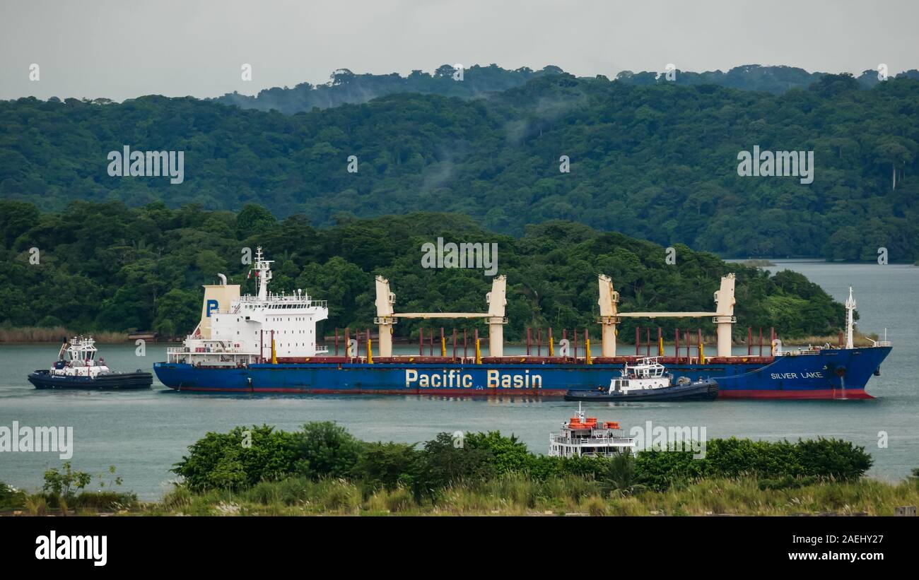 Bulk Carrier Schiff Pacific Basin in der Gatun See, manövrieren durch Schlepper, warten die Gatun Schleusen eingeben Stockfoto