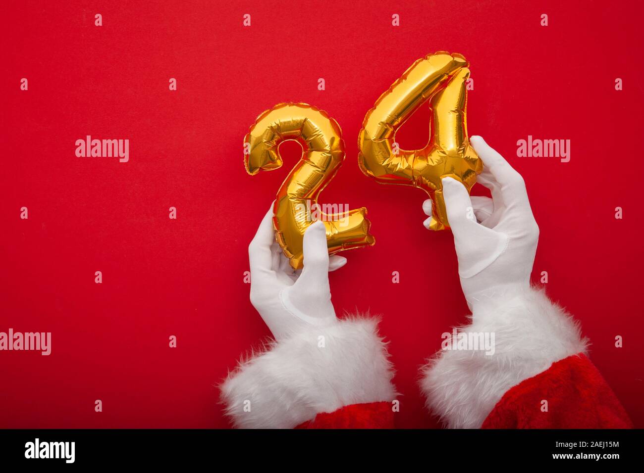 Santa Hände halten 24. Dezember gold Luftballons. Vater Weihnachten Hintergrund Stockfoto