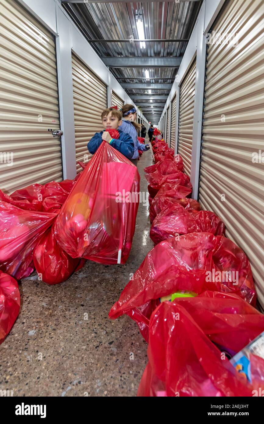 Madison Heights, Michigan - Freiwillige Helfer aus dem jüdischen, christlichen und muslimischen Organisationen gespendet, sortieren und verpacken Geschenke für benachteiligte Kinder Stockfoto