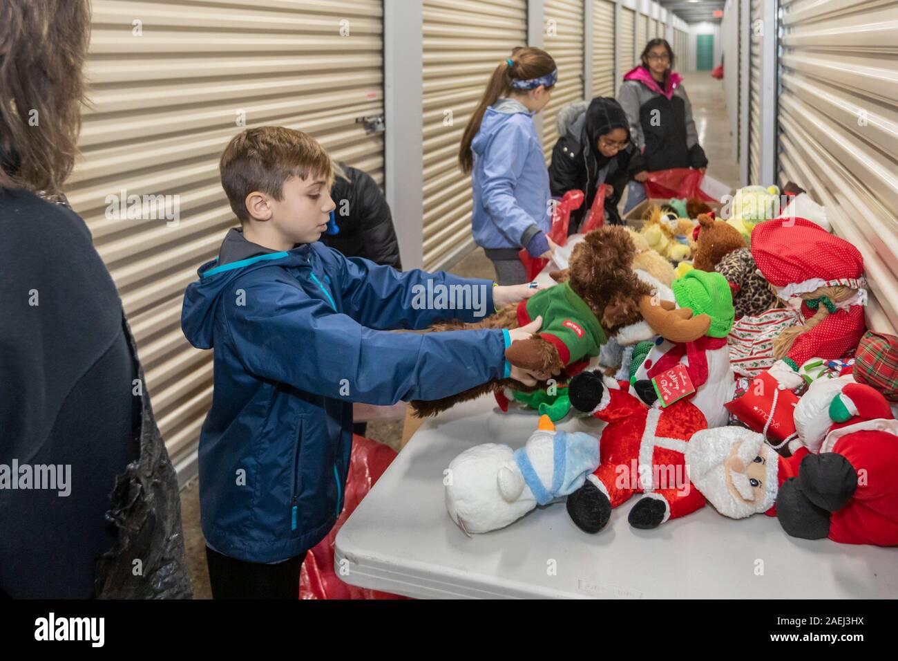 Madison Heights, Michigan - Freiwillige Helfer aus dem jüdischen, christlichen und muslimischen Organisationen gespendet, sortieren und verpacken Geschenke für benachteiligte Kinder Stockfoto