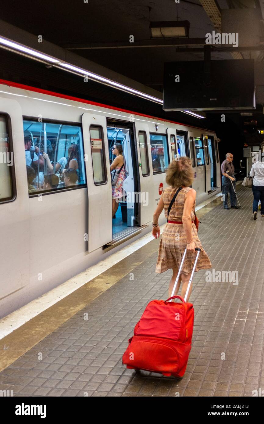 Frau schleppen einen Koffer in Barcelona Metro, Barcelona, Spanien Stockfoto