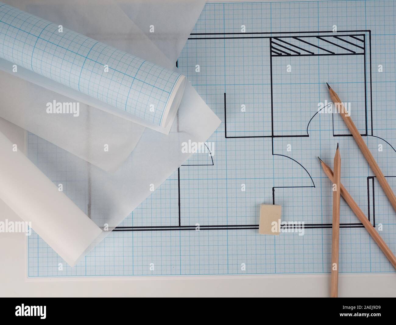 Architekturzeichnungen für das Layout des Wohnungsdesigns, Millimeterpapier, Zeichenpapier in einer Rolle und Bleistifte Stockfoto