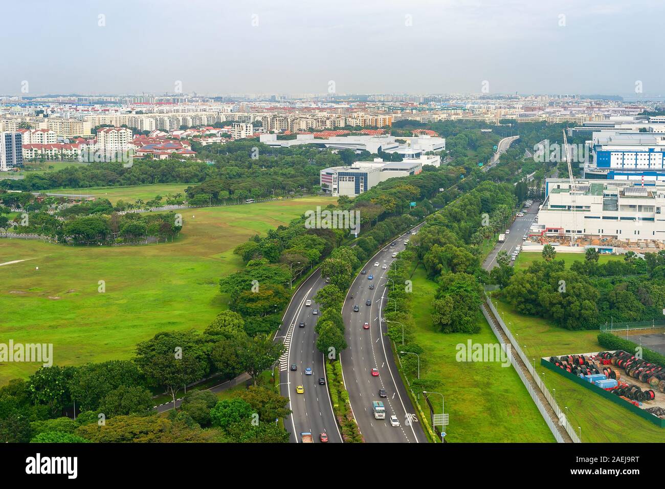Luftaufnahme von Singapur mit PKW-Verkehr auf der Autobahn, grüne Landschaft mit modernen Stadtbild im Hintergrund Stockfoto