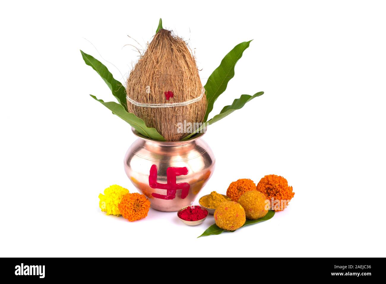 Kupfer Kalash mit Kokos, mango Leaf, Haldi, Kumkum und Süßigkeiten mit Ringelblume Blumendekoration auf einem weißen Hintergrund. Wesentlich in der hinduistischen Puja. Stockfoto