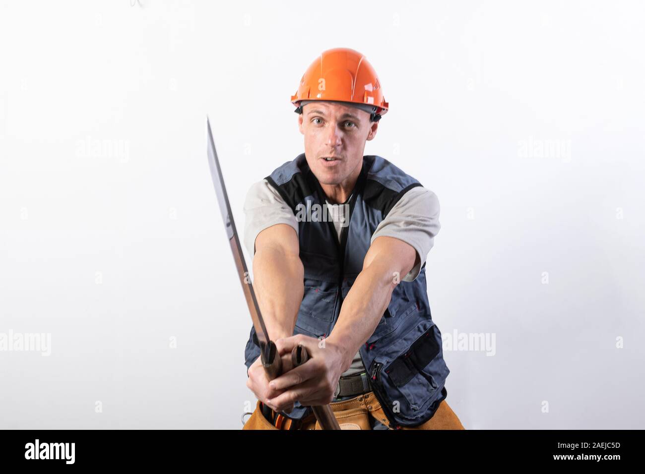 Die Builder zeigt einen Kampf mit einem Katana. Handwerker mit Helm und Arbeitskleidung. Stockfoto