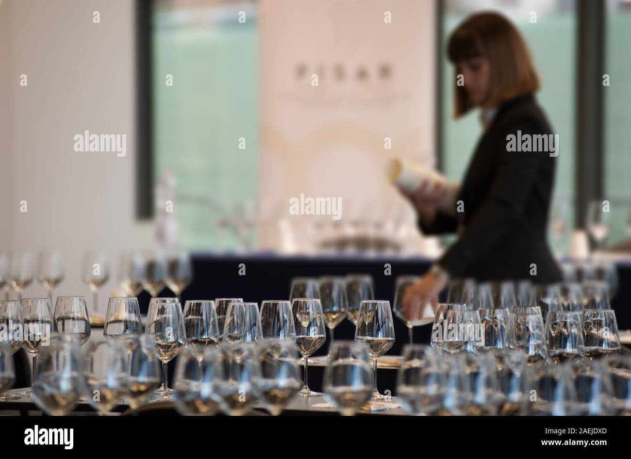 Kellnerin stellen Sie die Tabellen mit Crystal gobles Für eine Weinprobe Werkstatt. Catering Service und Personal bei der Arbeit. Stockfoto