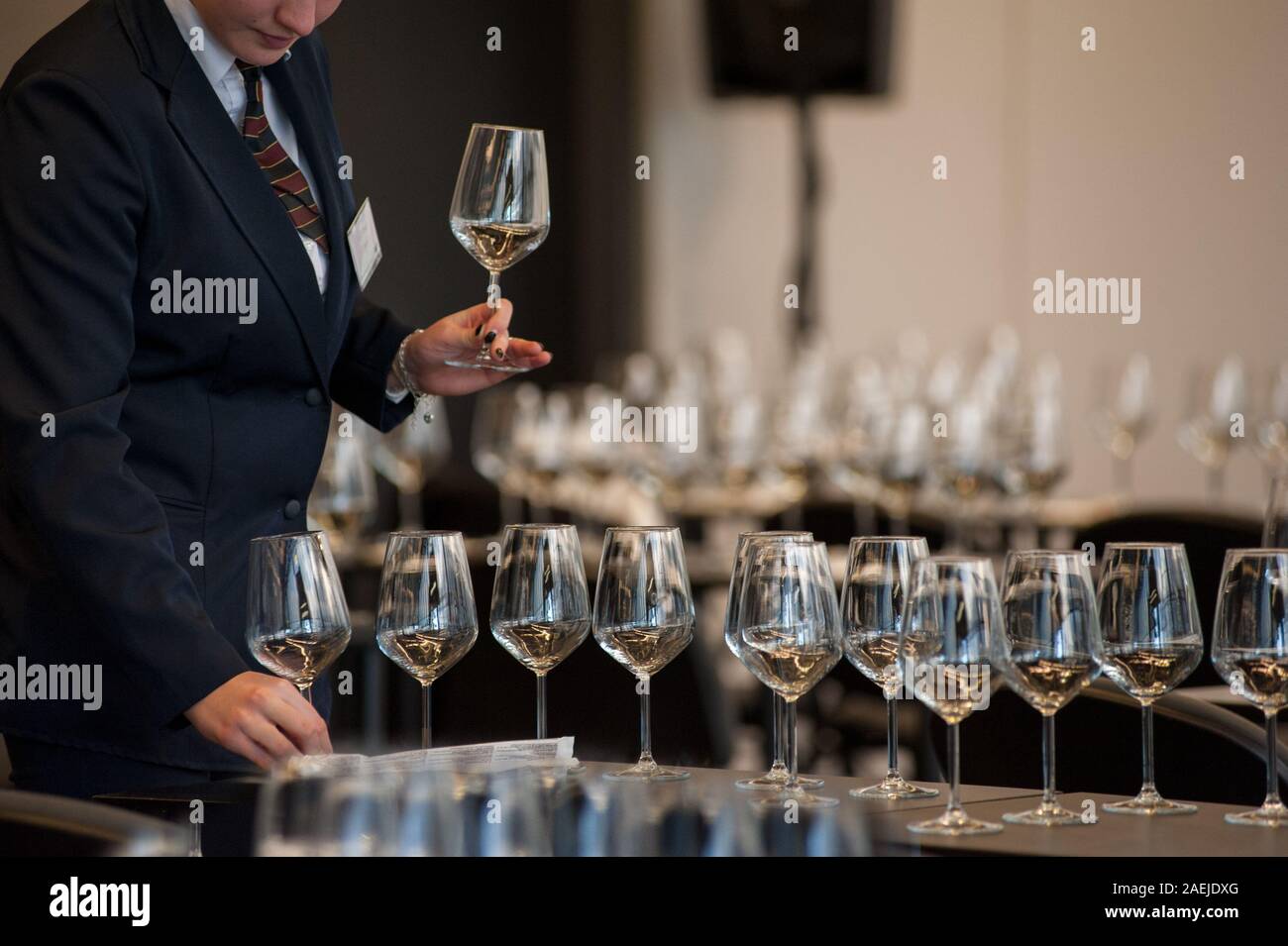 Kellnerin stellen Sie die Tabellen mit Crystal gobles Für eine Weinprobe Werkstatt. Catering Service und Personal bei der Arbeit. Stockfoto