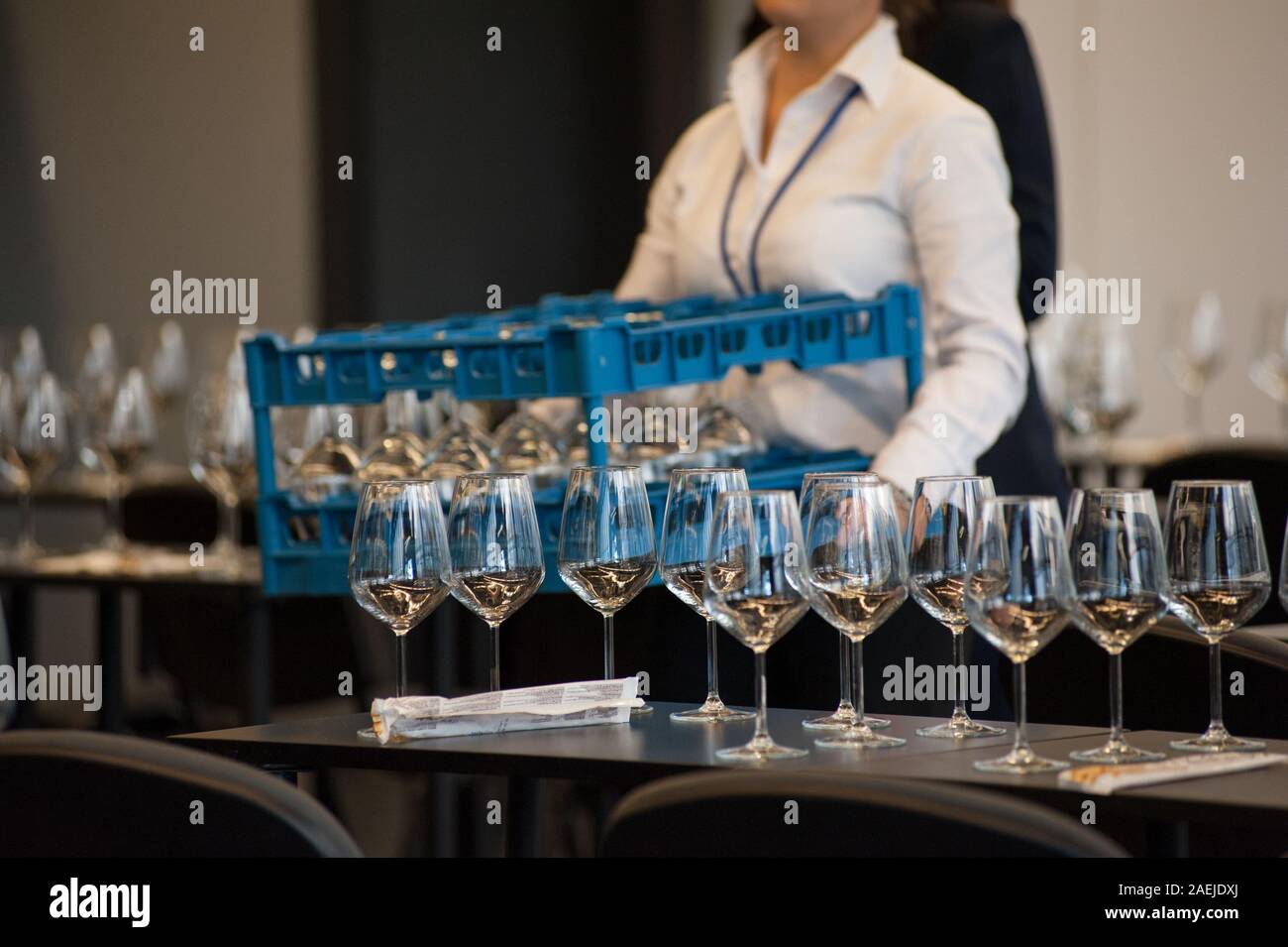 Kellnerin stellen Sie die Tabellen mit Crystal gobles Für eine Weinprobe Werkstatt. Catering Service und Personal bei der Arbeit. Stockfoto
