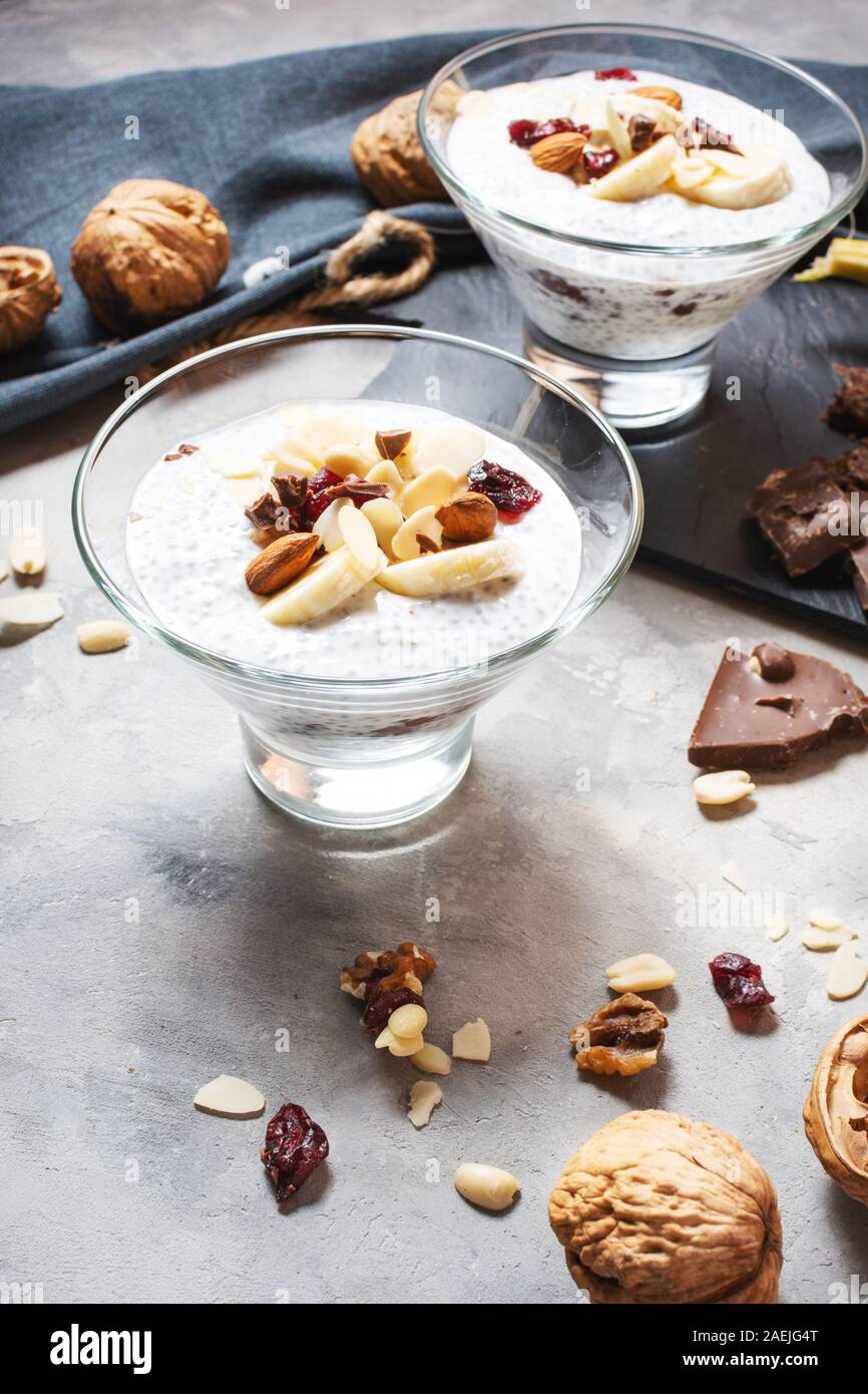 Chia pudding parfait Blätterteig mit Banane, Joghurt und die Muttern an den konkreten Hintergrund Stockfoto