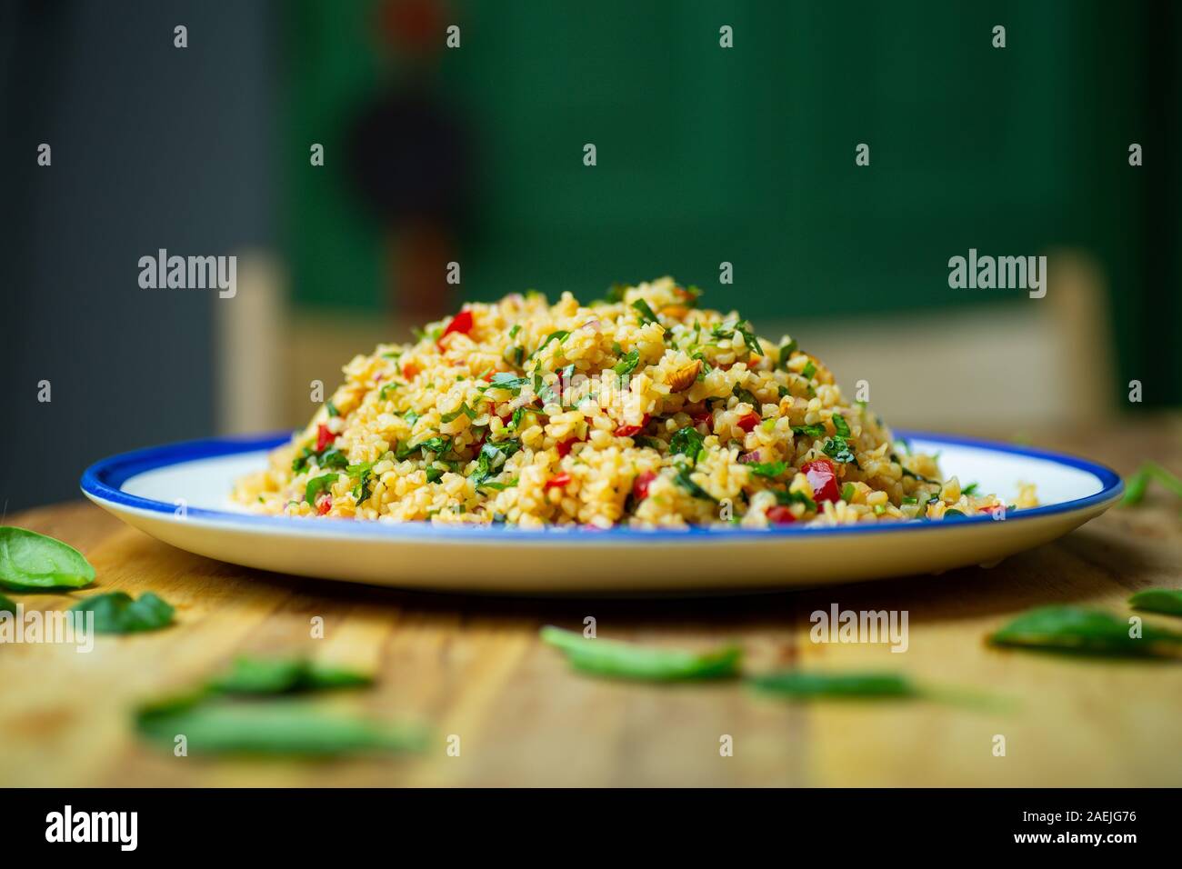 Hausgemachte veganes Essen (vegane) von Bulgur Salat Müsli mit frischem Gemüse, Spinat, Avocado, Gewürzen und Olivenöl. Gesund essen Bio eco-Konzept. Stockfoto