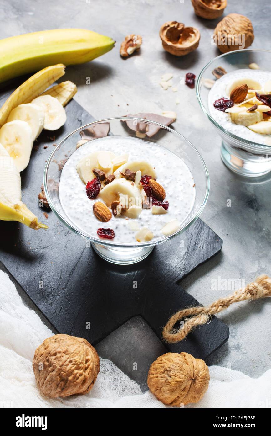 Chia pudding parfait Blätterteig mit Banane, Joghurt und die Muttern an den konkreten Hintergrund Stockfoto