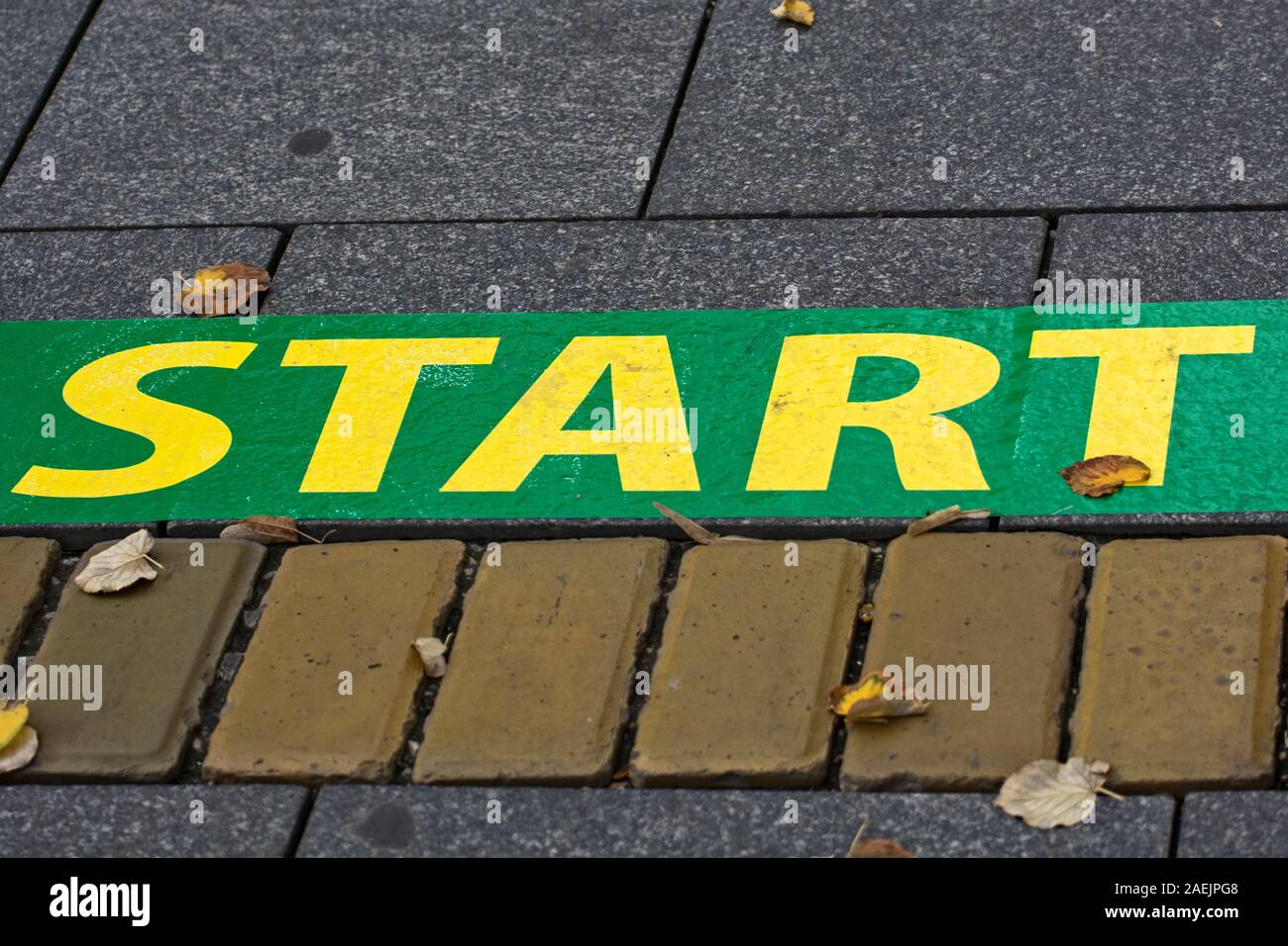 Ort als Start markiert. Ein Platz, zum zu beginnen und neue Erfolge. Symbolisches Zeichen auf dem Bürgersteig. Stockfoto