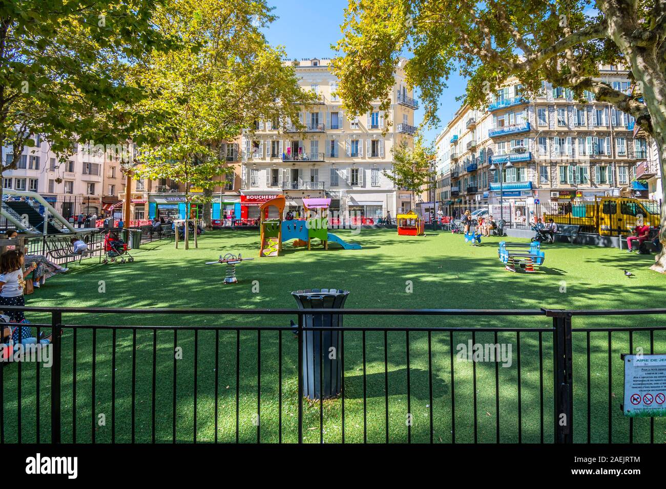 Kinder spielen in einem kleinen eingezäunten Spielplatz Schulhof in das städtische Zentrum von Nizza, Frankreich. Stockfoto