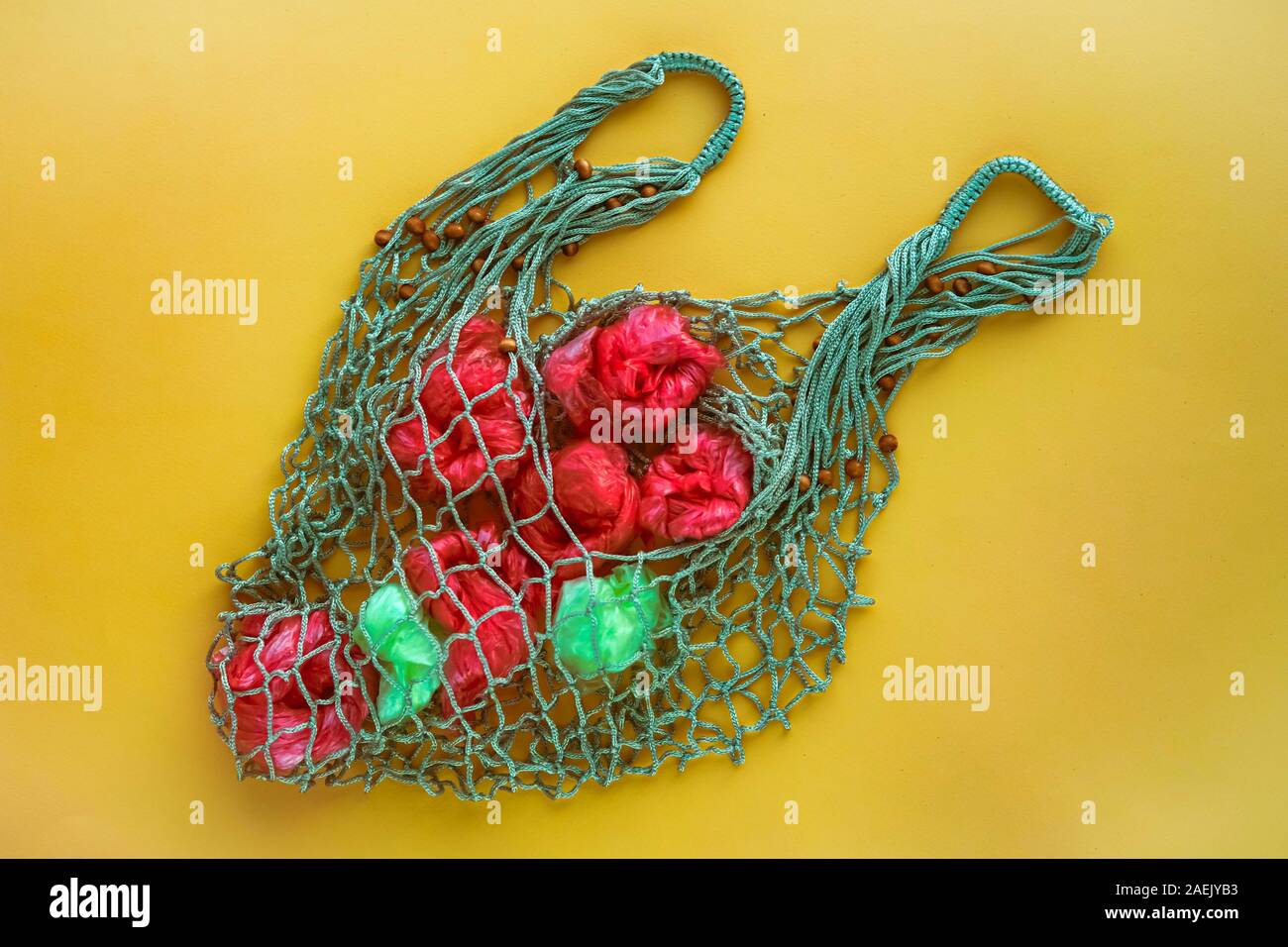 Net Tasche voll von künstlichen Früchten von grünen und roten Plastiktüten. Keine Kunststoff-Konzept. Umweltprobleme. Stockfoto