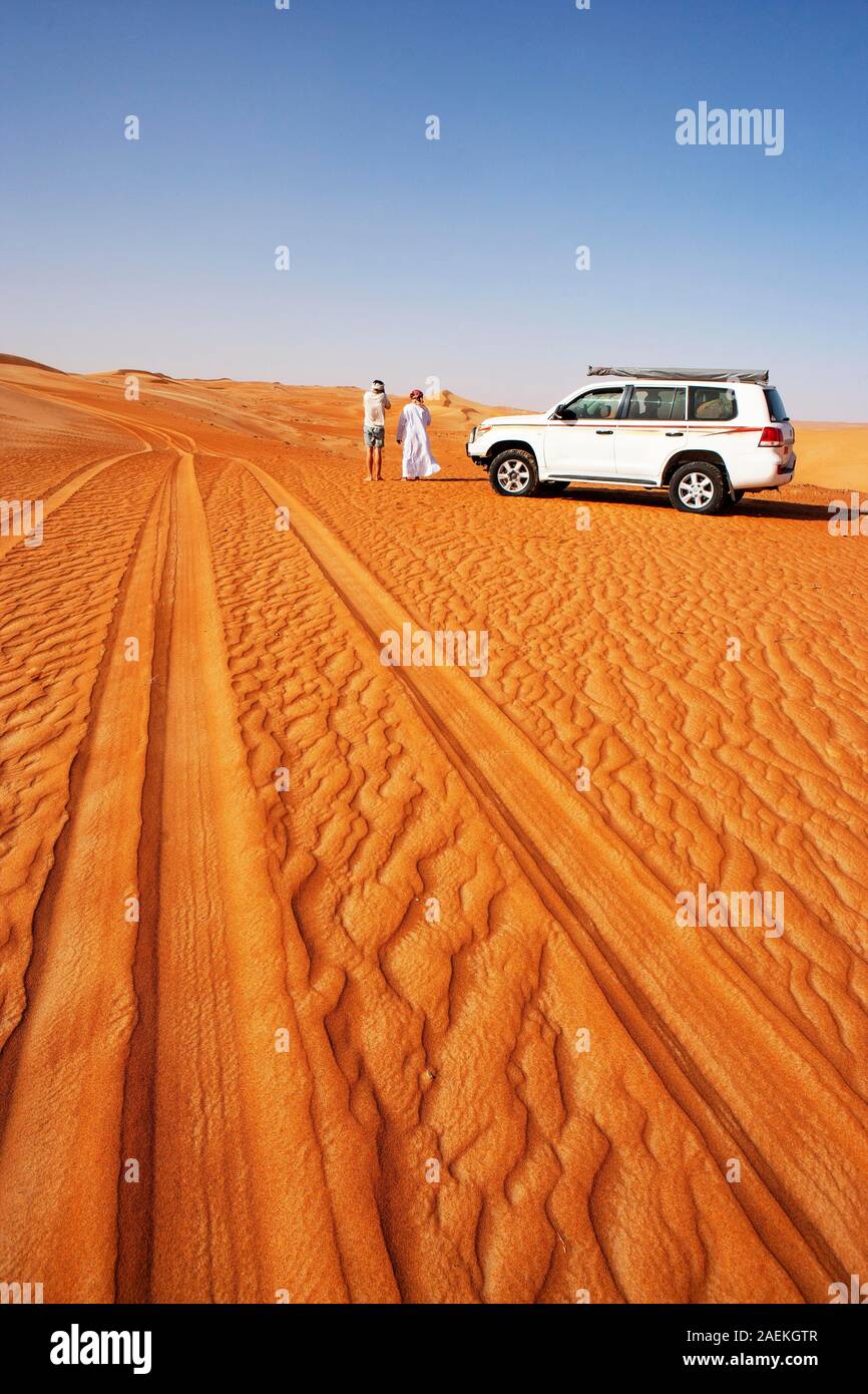 Reifen Spuren im Sand, touristische und Beduinen neben Geländewagen, Wüste, Wüste Rimal Wahiba Sands, Oman Stockfoto