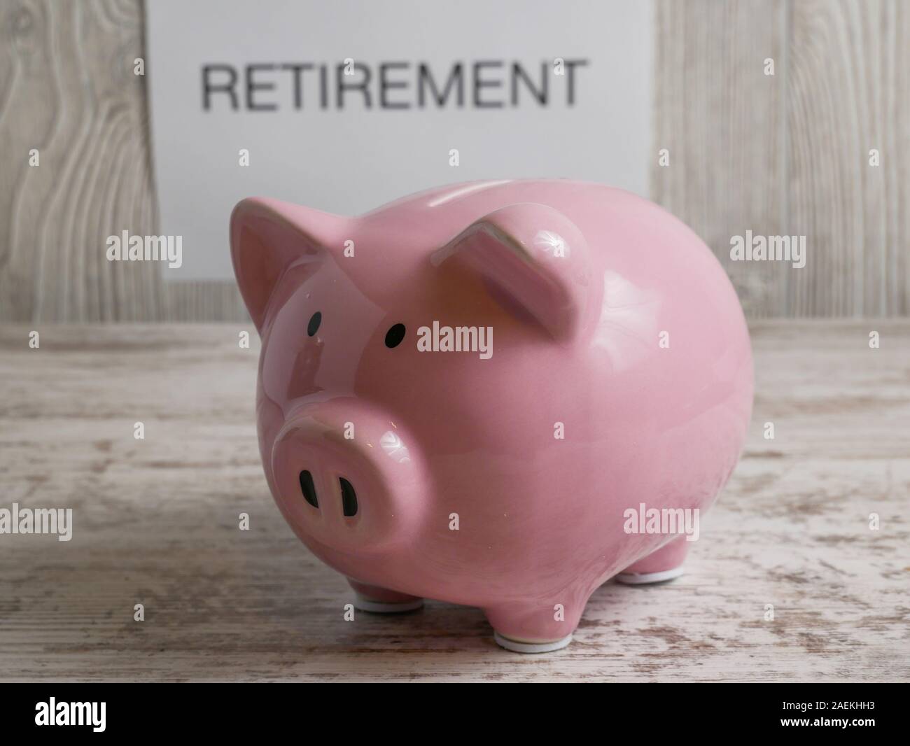 Hand Geld in ein Sparschwein mit einem Schild hinter, die besagt, dass in den Ruhestand Stockfoto