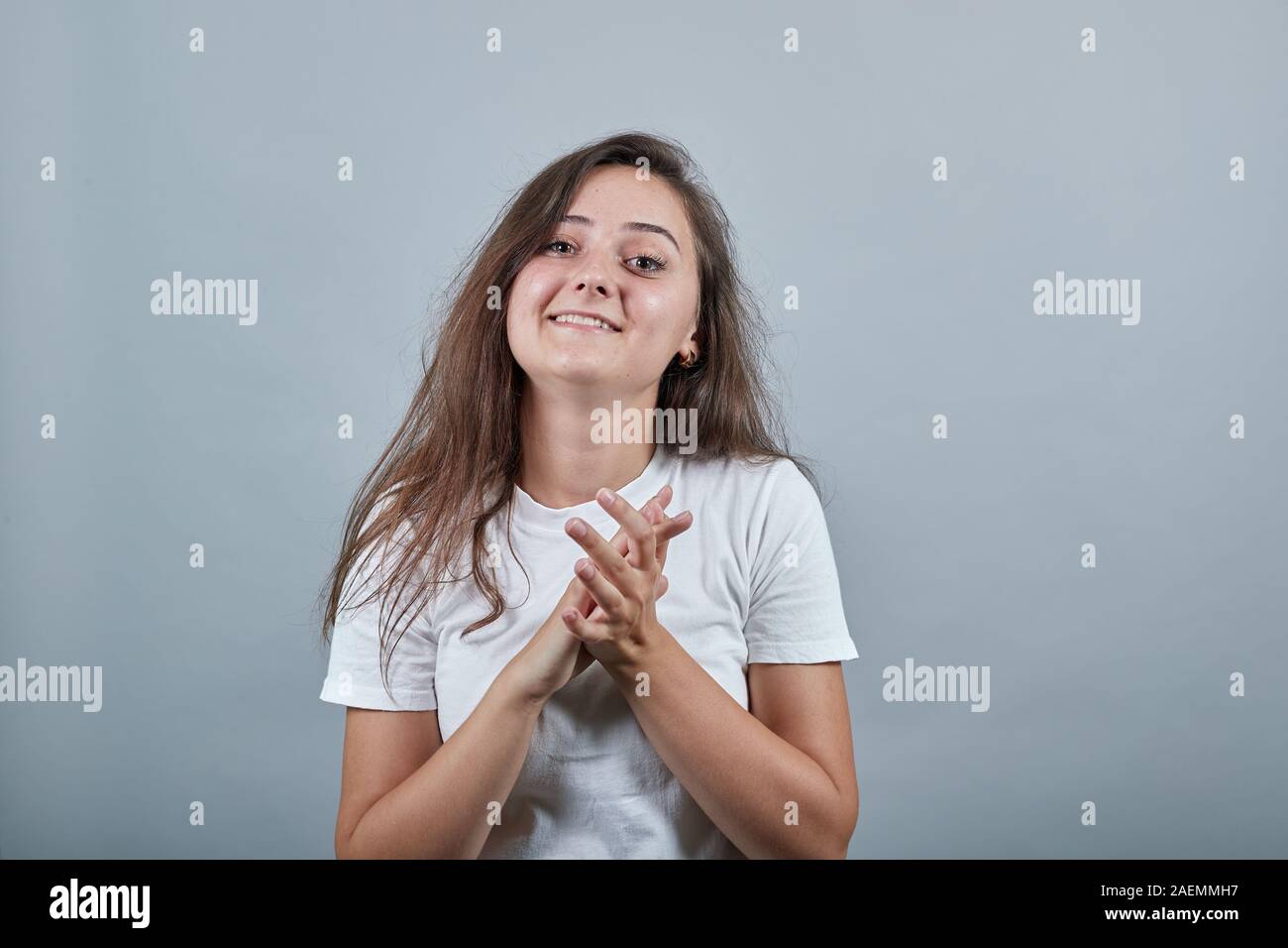 Junge Mädchen applouding und lächelnd über isolierte graue Wand Stockfoto