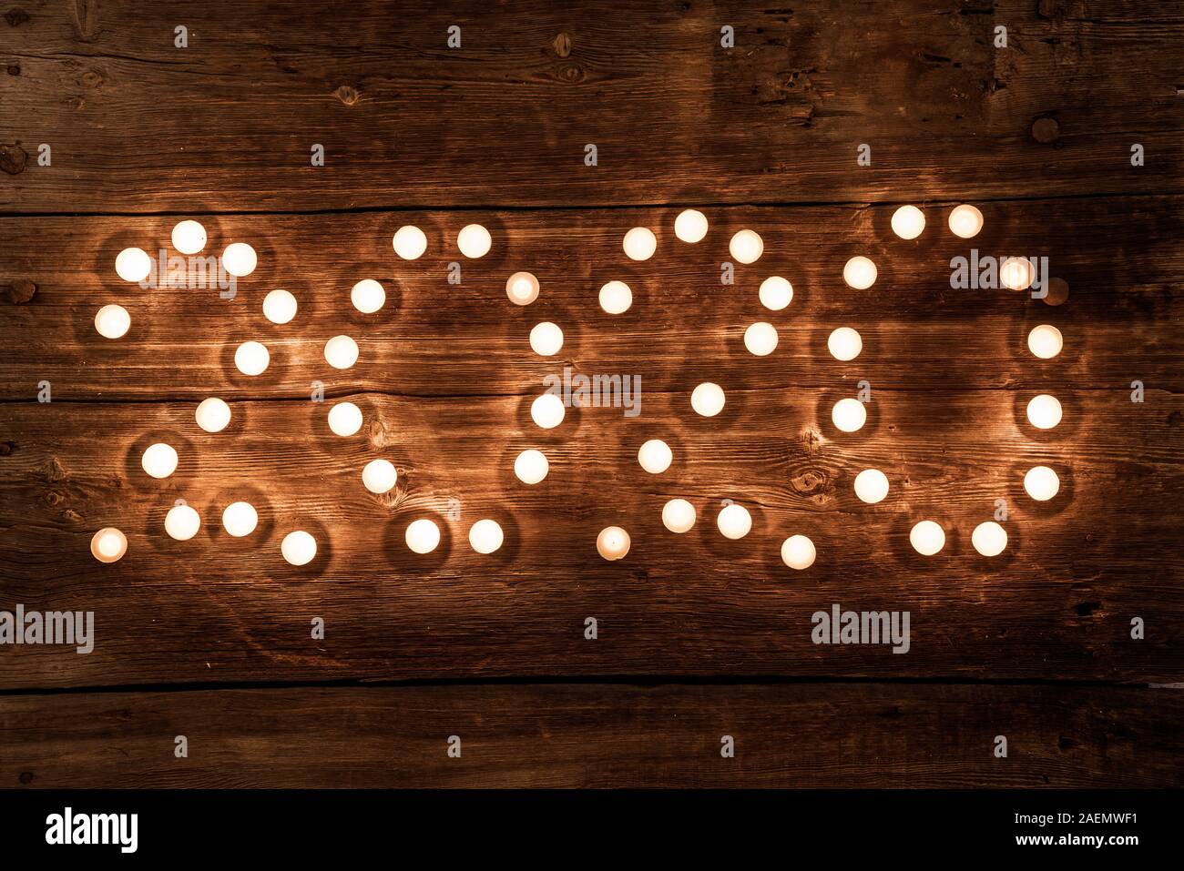 2020 Neue Jahr Konzept mit Teelicht Kerzen auf Holz- Hintergrund. Stockfoto