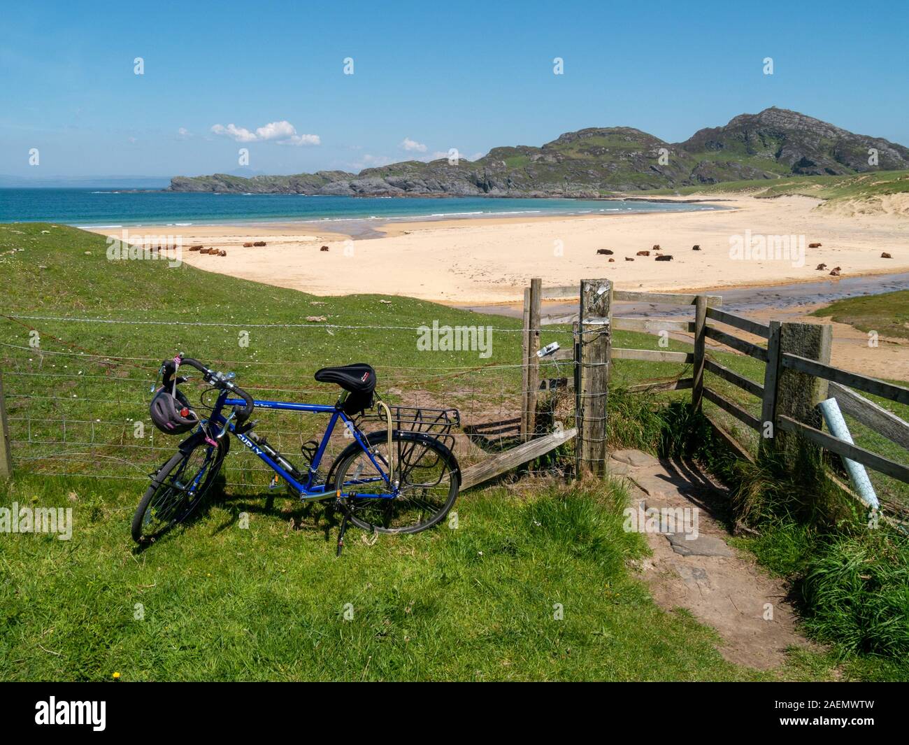Fahrrad durch Zaun und Tor am Eingang, die mit der Abgelegenheit und der schöne Sandstrand von Kiloran Bay im Sommer, von der Insel Colonsay, Innere Hebriden, Schottland, Großbritannien Stockfoto