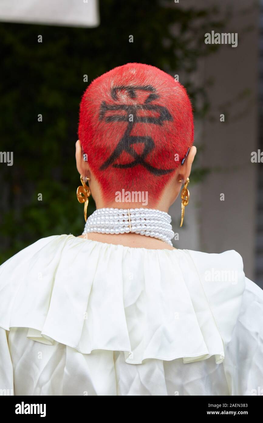 Mailand, Italien - 22. SEPTEMBER 2019: Frau mit roten Haaren und schwarzen Ideogramm auf Kopf vor Fila fashion show, Mailand Fashion Week street style Stockfoto
