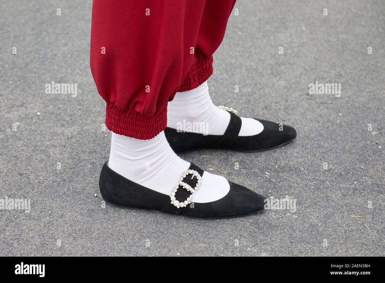 Mailand, Italien - 22. SEPTEMBER 2019: Frau mit roten Hosen, weiße Socken und schwarze Schuhe mit Edelsteinen vor Gucci fashion show, Mailand Fashion Week Straße Stockfoto