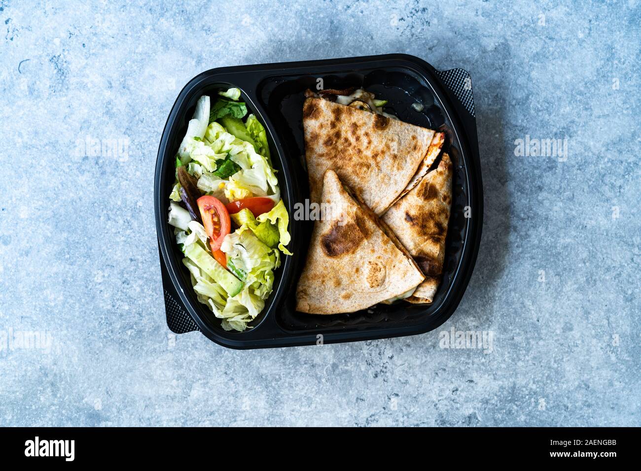 Nehmen Veggie Italienische geschlossen Calzone Pizza Scheiben mit Salat in Kunststoff Container/Paket. Bereit, um zu essen und zu dienen. Stockfoto