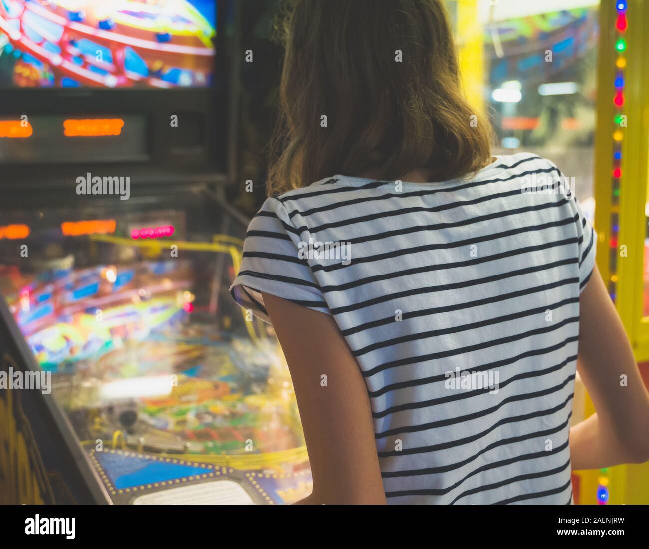 Kleine Mädchen spielen Pinball spiel in Theme Park. Stockfoto