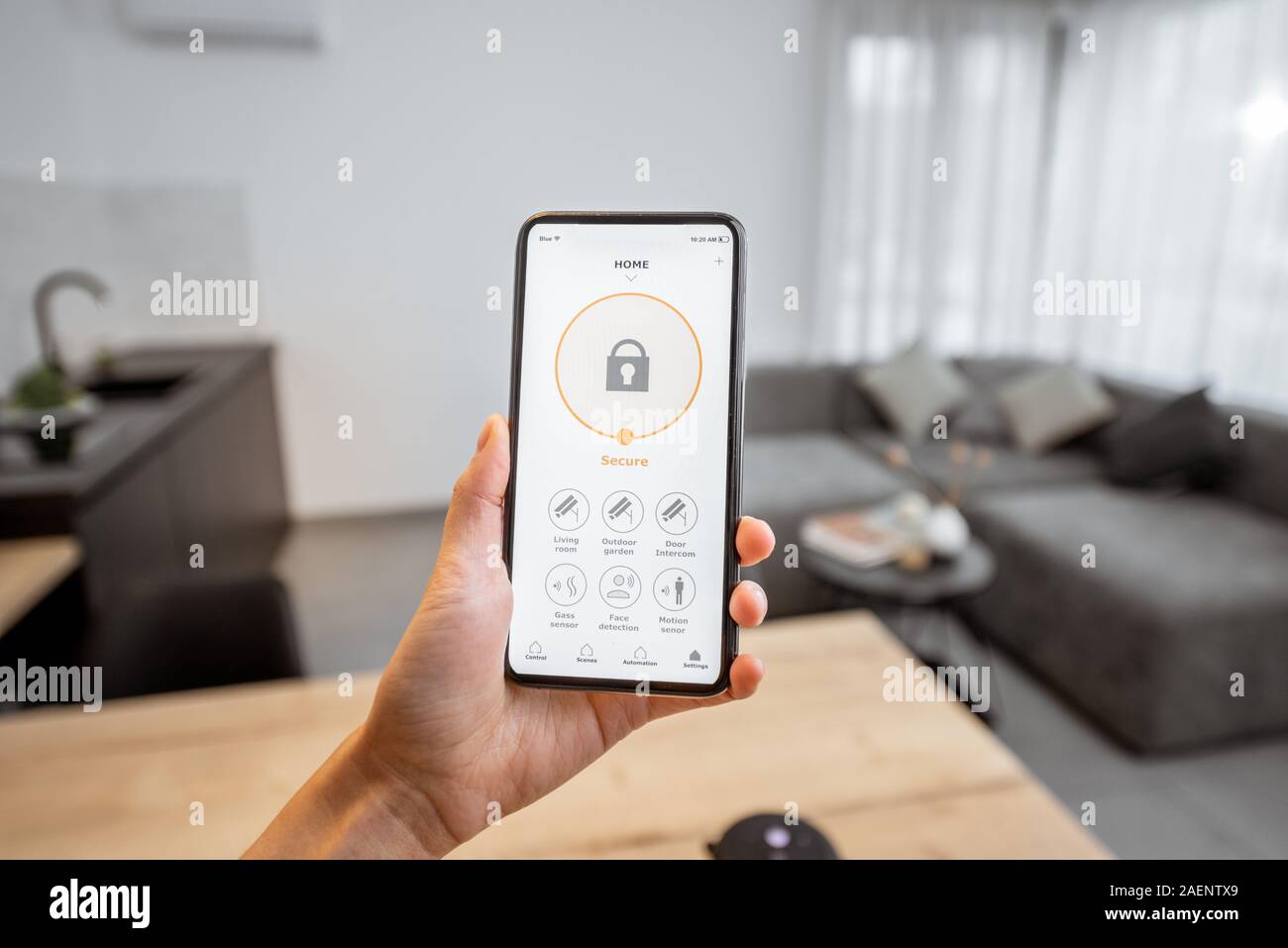 Halten Sie ein Smartphone mit gestartete Programm für die Sicherheit Zuhause. Konzept der Steuerung und Verwaltung Startseite sicherheit von einem mobilen Gerät Stockfoto