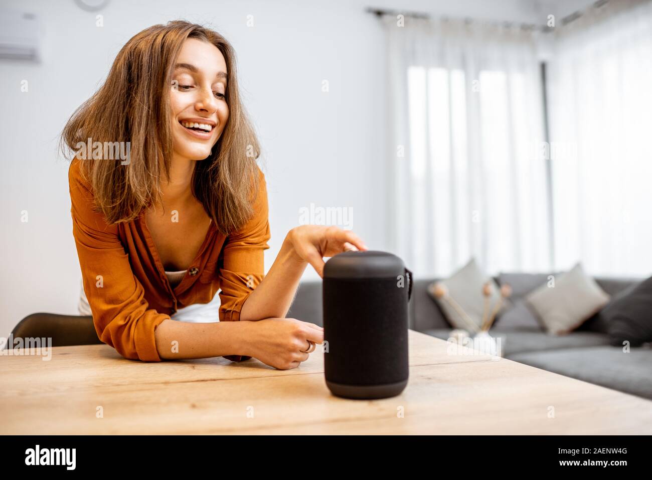 Junge Frau Einschalten wireless smart Spalte zu Hause. Konzept einer Smart Home wireless Geräte. Konzept der "Smart Home" und Sprachsteuerung Stockfoto