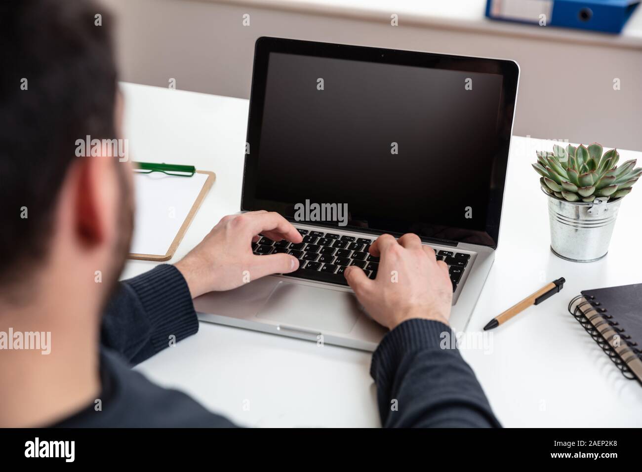 Bildschirm mockup. Mann bei der Arbeit mit einem schwarzen, leeren Bildschirm Laptop auf Holz Schreibtisch, Büro Background, kopieren Raum Stockfoto