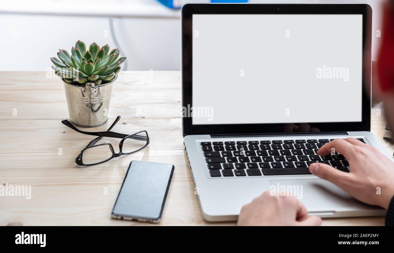 Bildschirm mockup. Mann bei der Arbeit mit einem weißen leeren Bildschirm Laptop auf Holz Schreibtisch, Büro Background, kopieren Raum Stockfoto