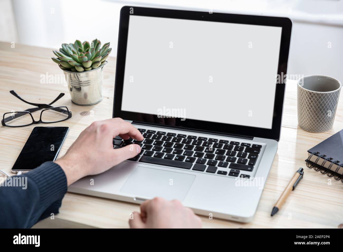 Bildschirm mockup. Mann bei der Arbeit mit einem weißen leeren Bildschirm Laptop auf Holz Schreibtisch, Büro Background, kopieren Raum Stockfoto