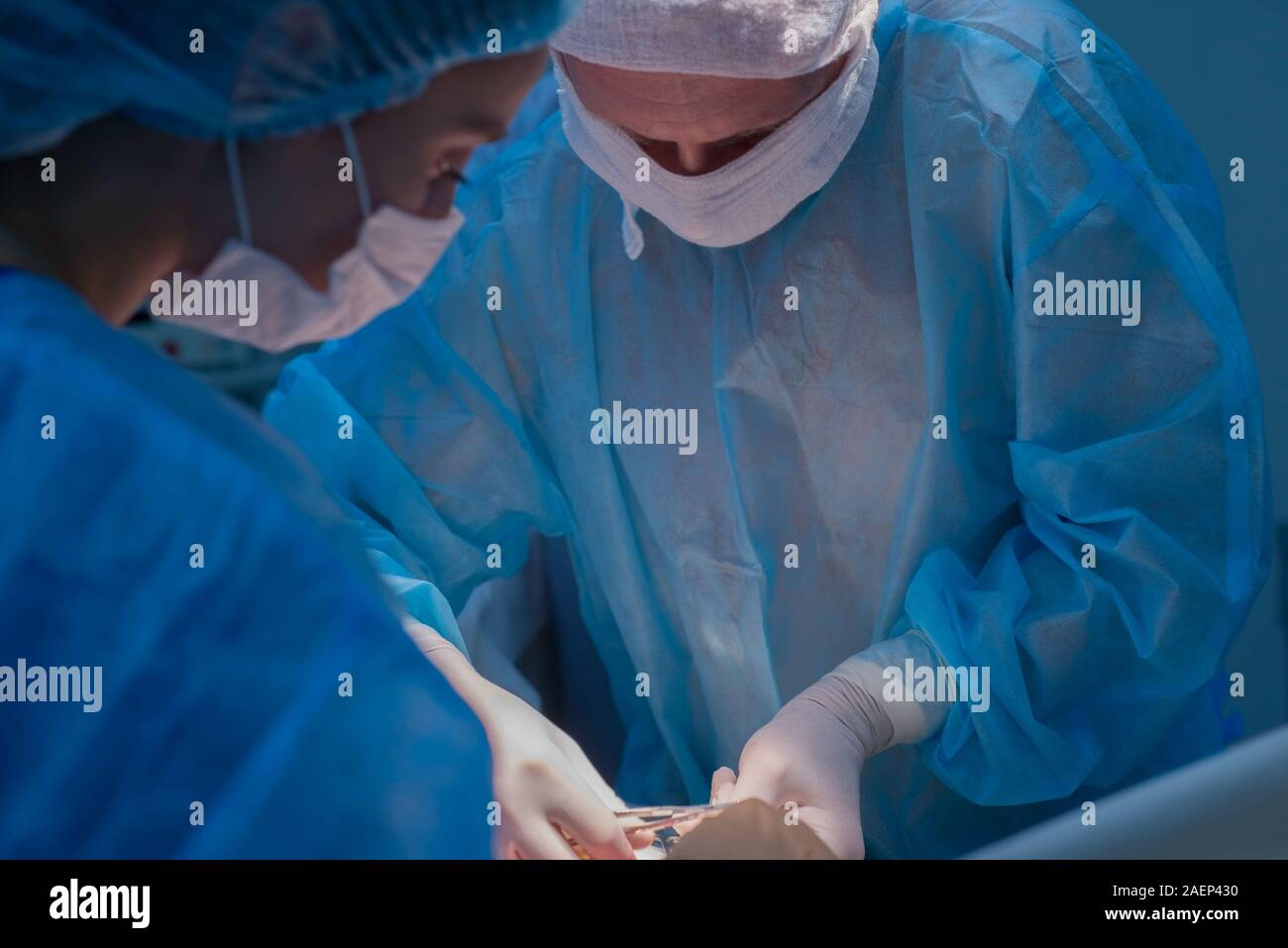 Chirurgen Kinder urologische Operationen durchführen. Ein Mann und eine Frau in einer Maske und einem blauen sterile Mantel in den Operationssaal. Ein Team von Chirurgen ist Co Stockfoto