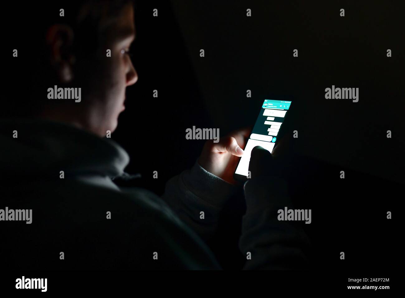 Teenager mit einem Smartphone, das Senden einer Nachricht. Teenager mit seinen zwei Daumen eine Nachricht auf der Tastatur seines Smartphones zu schreiben Stockfoto