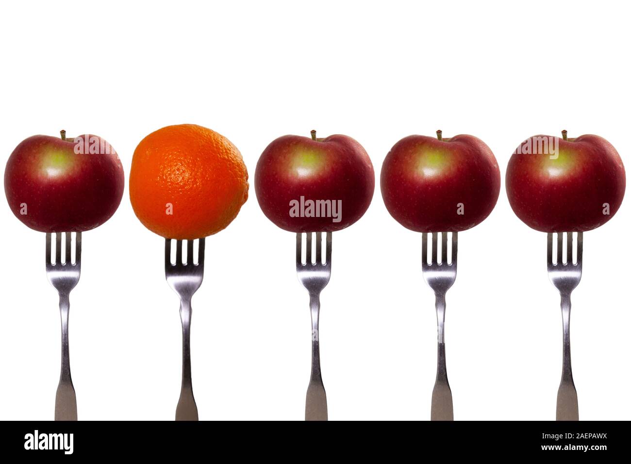 Äpfel und eine Orange auf der Gabel. Äpfel mit Birnen vergleichen. Stockfoto