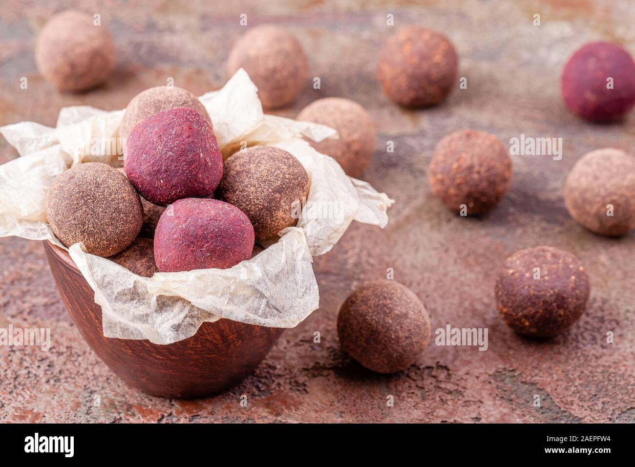 Nahaufnahme von hausgemachten Raw Vegan Cacao Energie Kugeln in der Schüssel mit Handwerk Papier Stockfoto