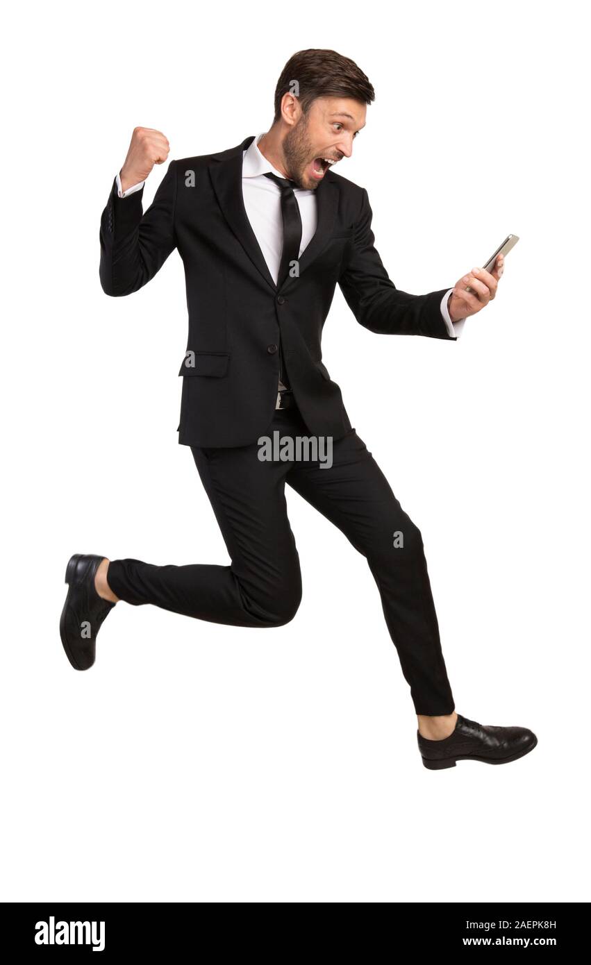 Aufgeregt Geschäftsmann springen Holding Telefon Gestik auf weißem Hintergrund Stockfoto