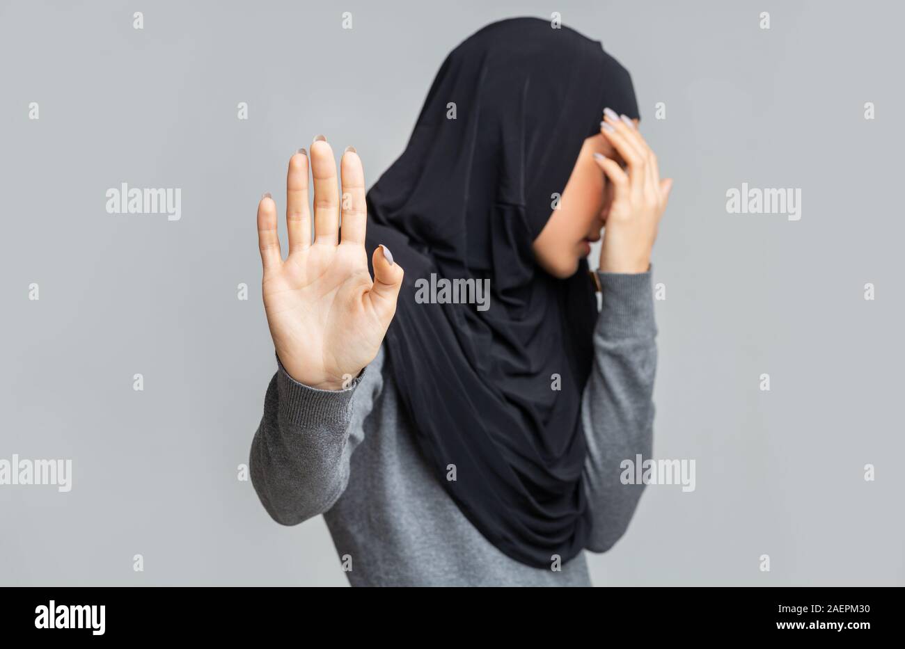 Muslimische Frau im Hijab, stop Geste und über ihr Gesicht Stockfoto