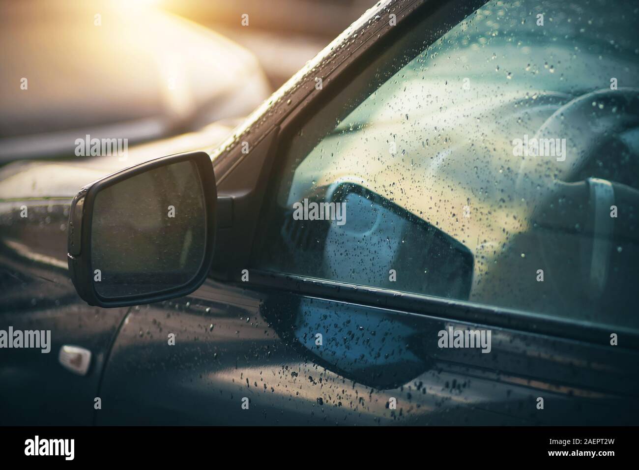 Der Regen - getränkte Fenster und Spiegel des Autos, die durch das Licht der Sonne, die gerade hinter den Wolken gekommen ist beleuchtet. Stockfoto