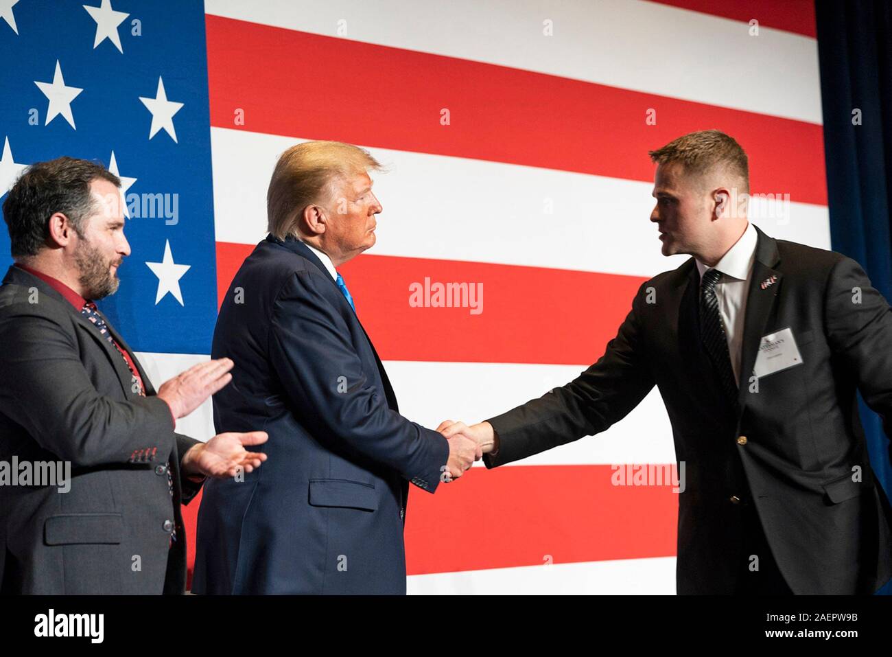 Us-Präsident Donald Trump begrüßt Armee Oberleutnant Clint Lorance und Armee Major Mathew Golsteyn auf die Bühne vor seiner Erläuterungen an der Florida Republikanische Partei mehr Abendessen Dezember 7, 2019 in Aventura, Florida. Beide Soldaten wurden vor kurzem die Begnadigung durch den Präsidenten Trumpf nach ihrer Verurteilung wegen Kriegsverbrechen in Afghanistan engagiert. Stockfoto