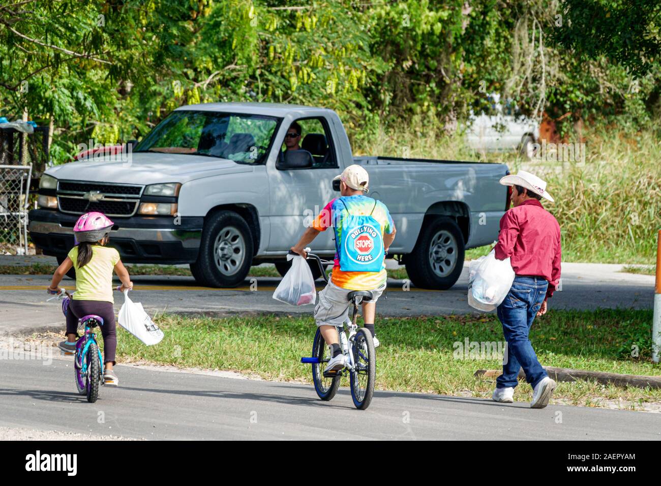 Florida Indiantown Hispanic Mann Mädchen Vater Tochter ländliche Stadt Familie Teen junge Mädchen Freunde Fahrrad Reiten Walking Pickup LKW Stockfoto