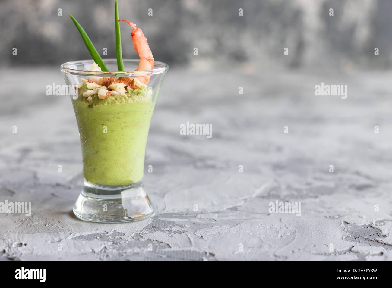 Avocado- und grüner Apfel Mousse mit Garnelen und Mandeln. Teil Vorspeise für ein Buffet oder Bankett in ein Glas. Stockfoto