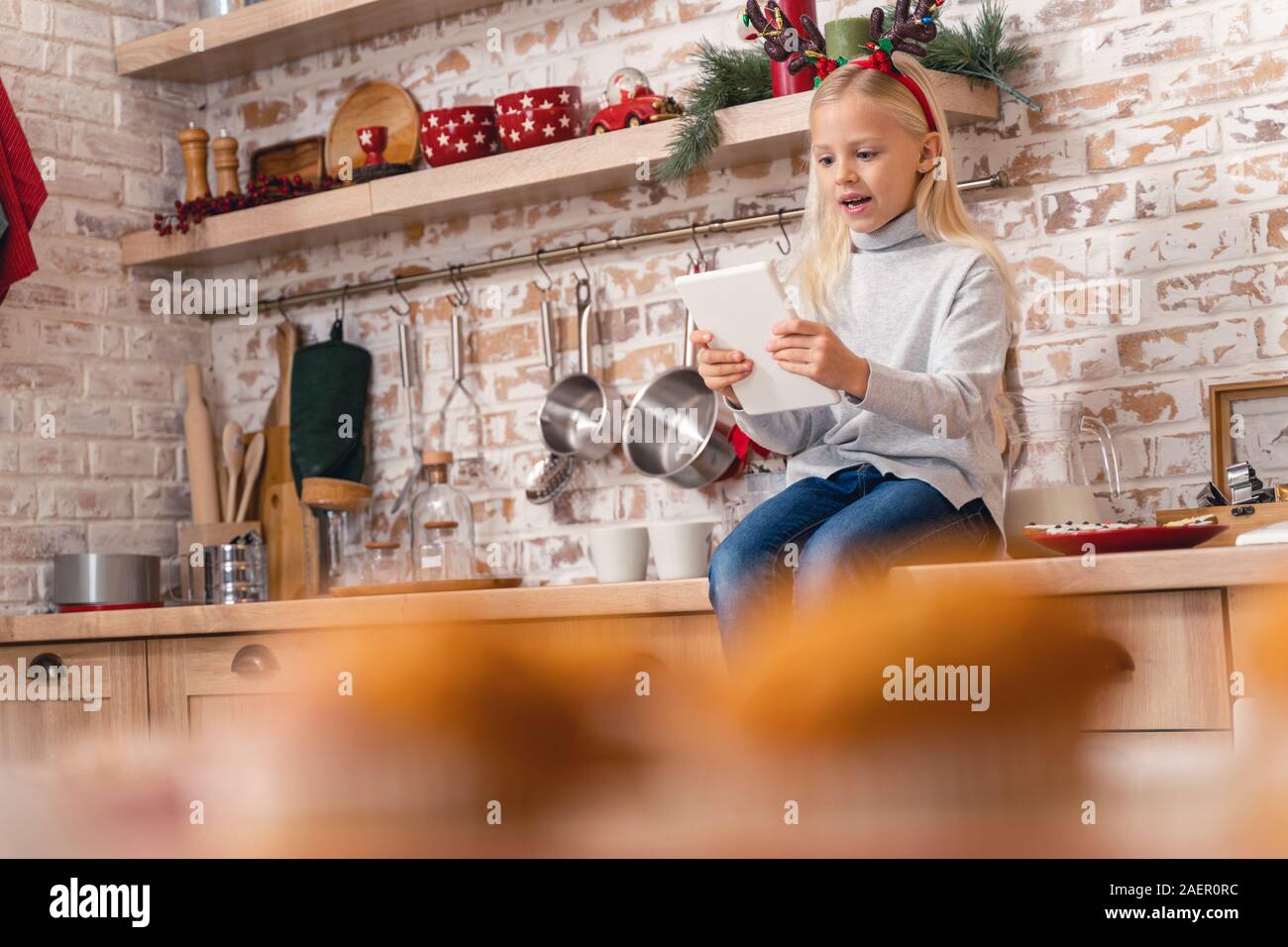 Wenig kaukasische Mädchen spielen online Spiele drinnen Stockfoto
